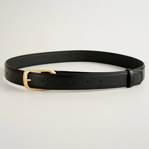 Détail d'une ceinture noire en similicuir pour femme avec boucle ardillon dorée polie