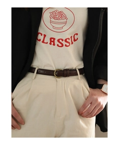 Detail eines schmalen dunkelbraunen Ledergürtels mit Vintage-Metallschnalle an weißer Hose