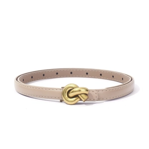 Detail of thin khaki belt with vintage gold knot buckle on white background