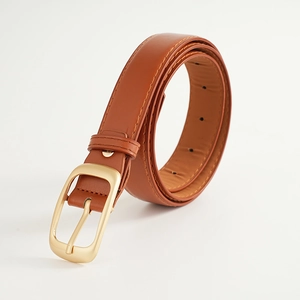 Détail d'une ceinture marron classique avec boucle dorée mate et coutures fines