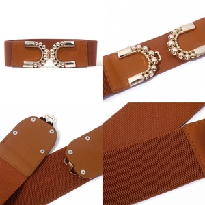 Détails d'une ceinture large élastique pour femme avec boucle dorée et bouton-pression