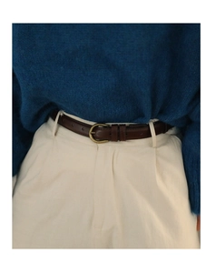 Nahaufnahme brauner Ledergürtel mit goldener Schnalle zu weißer Hose und blauem Pullover