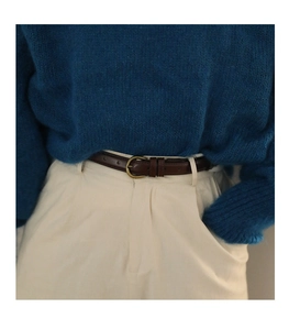 Detailansicht eines schmalen braunen Ledergürtels mit Vintage-Bronzeschnalle zu beiger Hose