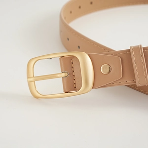 Gros plan sur une ceinture en similicuir kaki avec boucle ardillon rectangulaire dorée