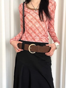 Detail of vintage brown suede wide belt with a large polished gold crescent buckle for women