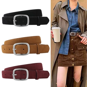 Macro detail of three frosted suede belts with retro silver buckles in black and brown