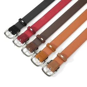 Close-up of five suede belts in various colors featuring vintage silver buckles and stitching