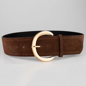 Close-up of a wide dark brown suede belt featuring a polished gold C-shaped metal buckle