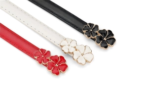 Detail of floral enamel metal buckles on colorful faux suede waist belts for women
