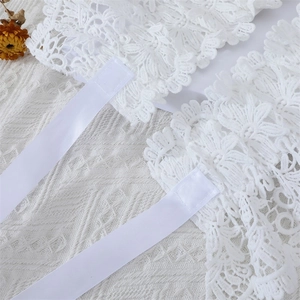 Détail de poignets en dentelle blanche avec rubans pour décoration de robe vintage