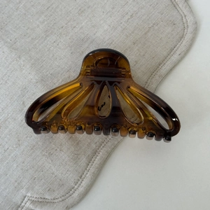 Macro view of shell-shaped tortoiseshell hair claw clip with smooth resin finish