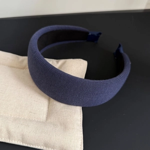 Detailed macro view of navy blue knitted wide headband with thick padded texture