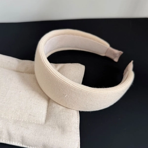 Detail showing the thick sponge padding and beige ribbed knit texture of the headband