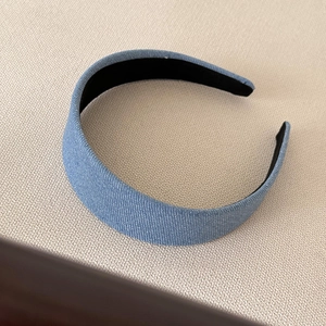 Detail shot of wide blue denim headband showing fine twill texture and inner lining