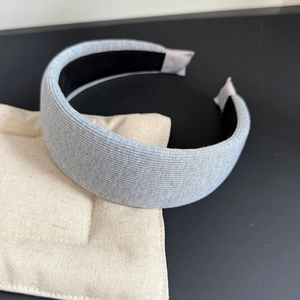 Detail view of light grey knitted headband featuring ribbed texture and black non-slip lining
