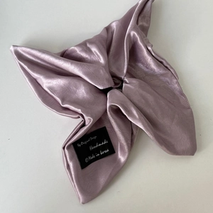 Elegant mauve satin scrunchie with handmade bow design and chic brand label detail