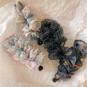 Set aus vier eleganten Blumen-Organza-Bananenspangen auf weißem Hintergrund präsentiert