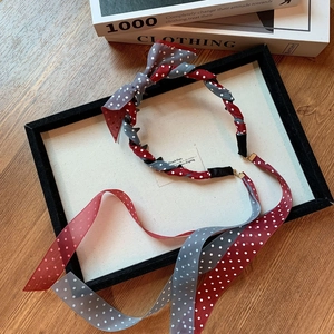 Vue détaillée du serre-tête en mousseline à pois rouge et gris avec de longs rubans