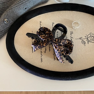 Pinza per capelli retrò leopardata con fiocco per capelli folti su uno sfondo elegante
