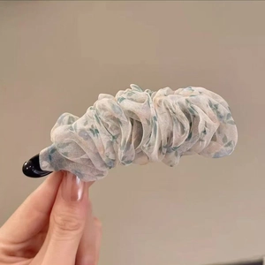 Detail der floralen Organza-Stofftextur an einer hellgrünen Bananen-Haarklammer für Damen
