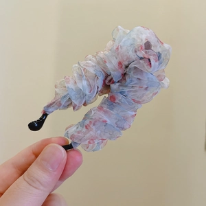 Detailaufnahme der floralen Organza-Stofftextur an einer Haarklammer im Korea-Stil