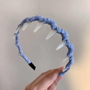 Detail view of blue polka dot fabric headband with inner plastic grip teeth for secure hair