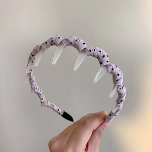 Detail of wave-shaped polka dot headband with non-slip plastic teeth for women