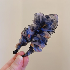 Detailansicht der plissierten Organza-Haarklammer mit floralen Mustern und Schichten