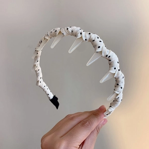 Close-up of polka dot headband with inner plastic teeth for hairstyle fixing