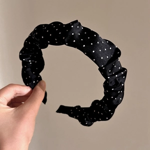 Serre-tête en satin plissé noir à pois blancs tenu à la main pour femmes