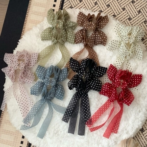 Pinces à cheveux à pois élégantes en sept couleurs sur un fond en peluche blanc