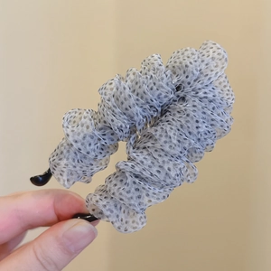 Detailaufnahme der grauen Organza-Haarklammer mit schwarzen Punkten und Netz-Design