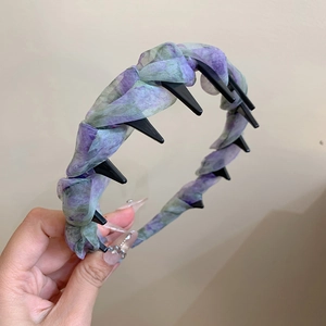 Vista dettagliata della trama in organza viola e dei denti antiscivolo dell'archetto per capelli