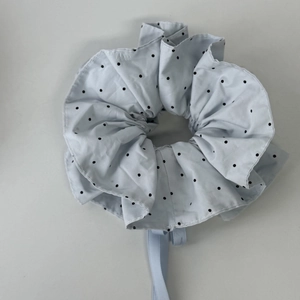 Détail du chouchou bleu clair à pois avec plis superposés et rubans fluides élégants