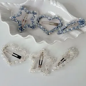 Elegant beaded star and heart hair clip set in blue and white crystals on a white tray