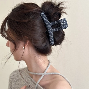 Detail of vintage denim fabric hair claw clip worn on model showing texture and strong grip