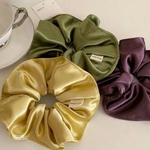 Three-piece satin scrunchie set in green yellow and purple with handmade labels