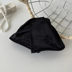Detail view of black velvet hair clip with elegant rose embossing and soft texture
