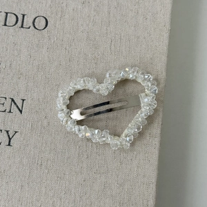 Close-up of heart-shaped hair clip with clear crystal beads and silver metal base