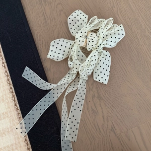 Pince à cheveux dorée élégante avec nœud en mousseline blanche à pois noirs et longs rubans
