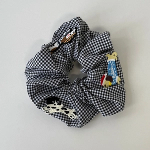 Close-up of gingham scrunchie featuring cute dog and cat embroidery patches