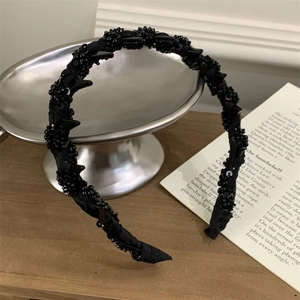 Elegant black beaded wavy headband featuring a textured 3D design and vintage style