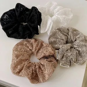 Lot de quatre chouchous en dentelle de style français en noir, blanc, argent et champagne