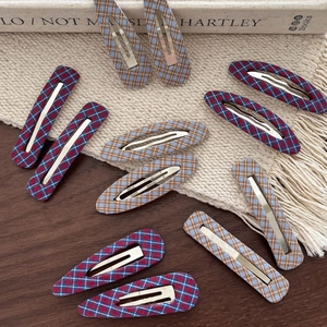 Retro plaid fabric hair clips in various shapes on a rustic wooden tabletop