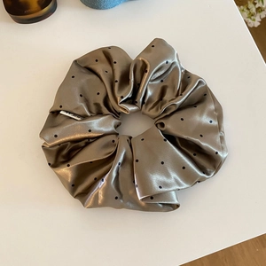 Detail of vintage champagne satin scrunchie with black polka dots and brand label