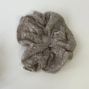 Vue détaillée du chouchou en tissu résille argenté avec étiquette tissée FMdrea