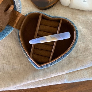 Detail of lavender acetate hair clip inside a heart-shaped denim jewelry box