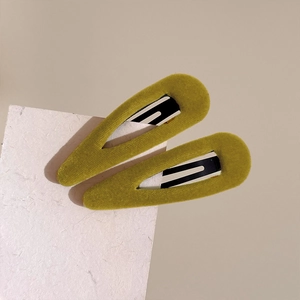 Close-up of olive green and yellow velvet BB hair clips on white cardstock