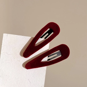 Detail showing two wine red velvet water drop hair clips on textured white paper card