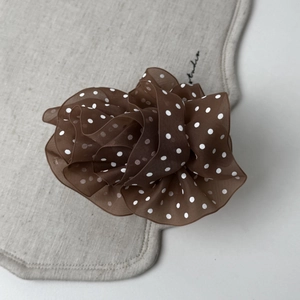 Close-up of brown polka dot organza hair scrunchie with soft mesh texture and folds